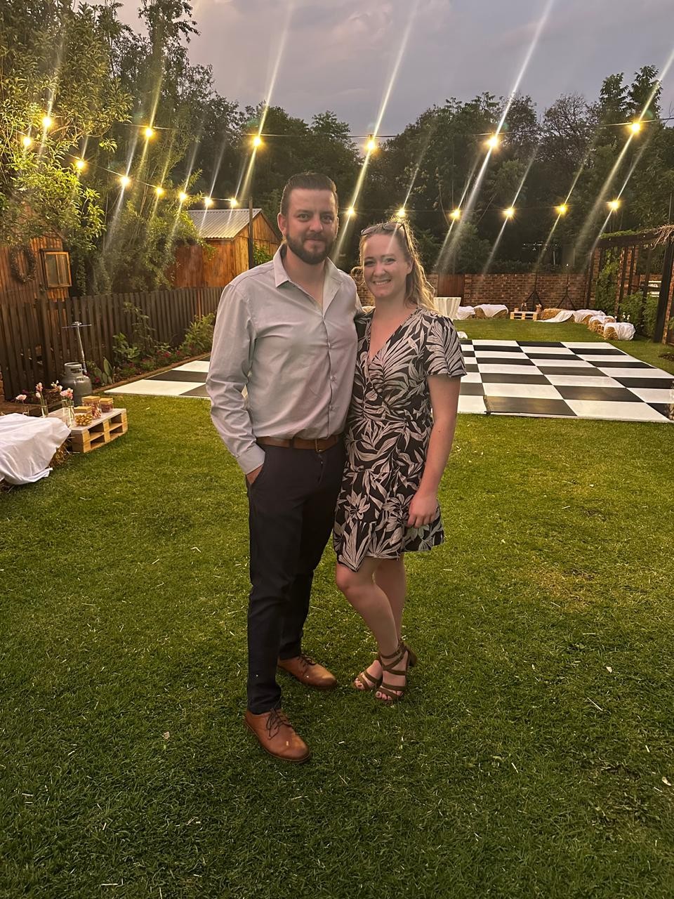 Amy and Andrew under glowing garden lights