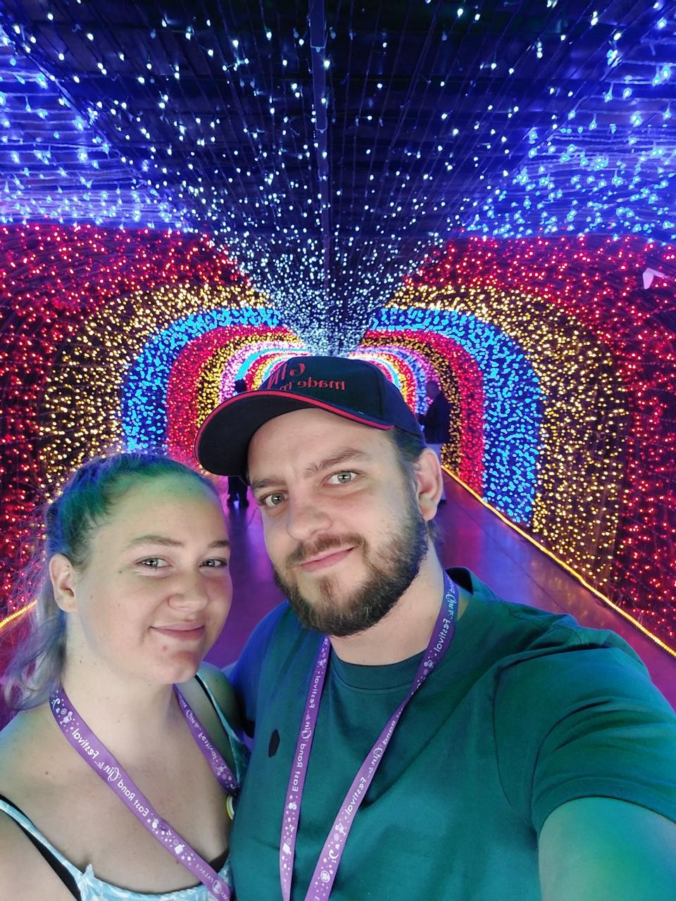 Amy and Andrew smiling under colourful tunnel lights