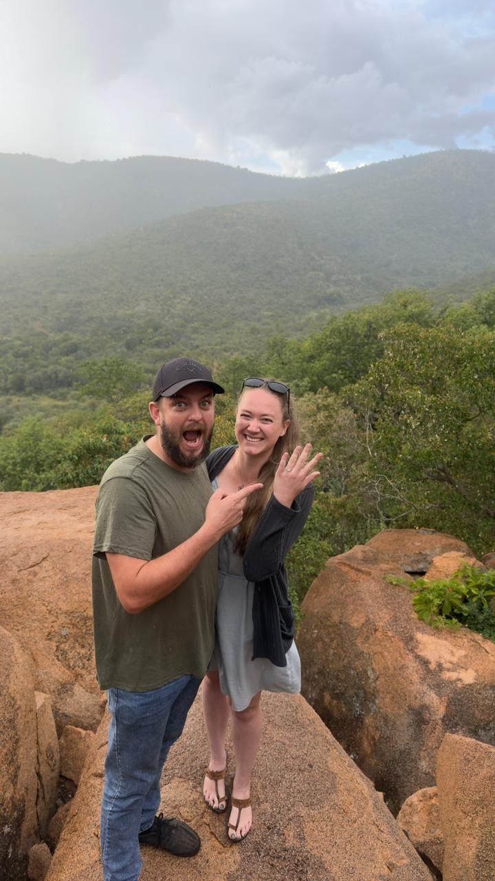 Amy and Andrew smiling together in the misty mountains